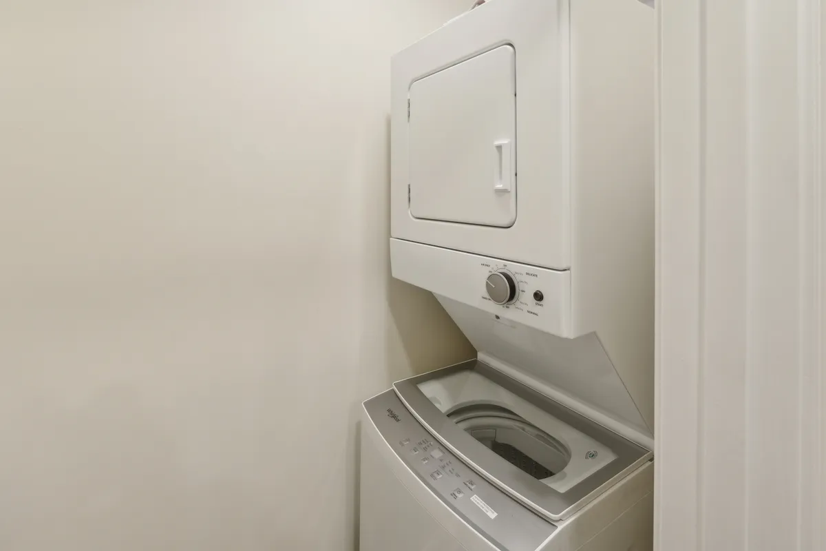 A neatly arranged laundry area with a washer and dryer, showcasing a practical and organized setup for in-unit laundry care.